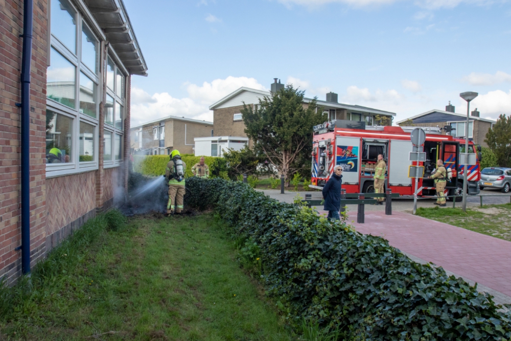 Brand tegen gevel school