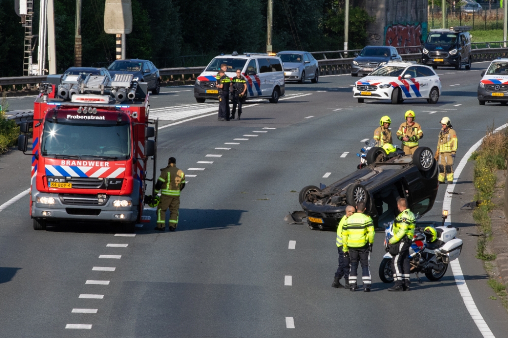 Auto over de kop, snelweg dicht