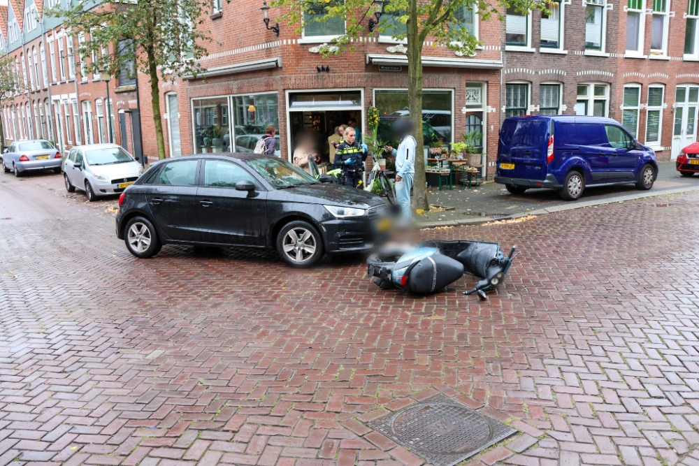 Scooterrijder ziet auto over het hoofd, botst en valt