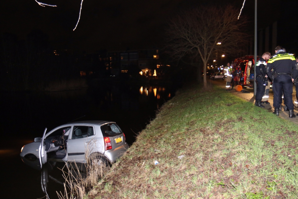 Auto rijdt met twee inzittenden het water in