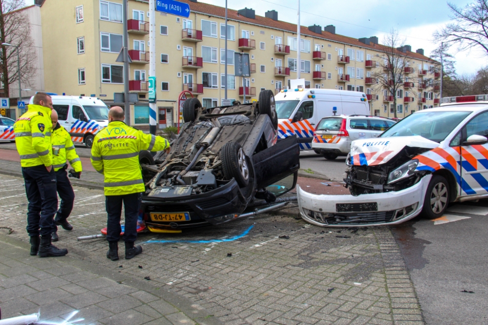 Auto over de kop na aanrijding met politieauto