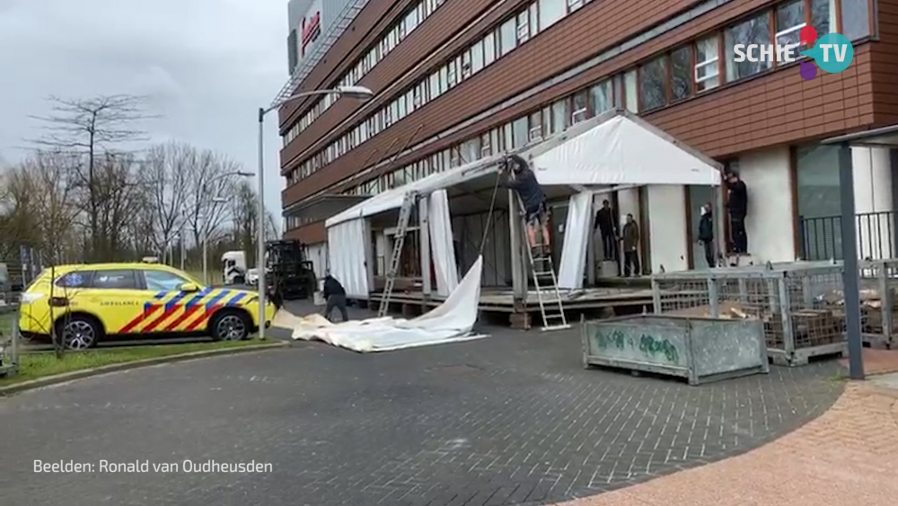 Met man en macht wordt gewerkt aan de opbouw van tenten bij het Vlietland ziekenhuis