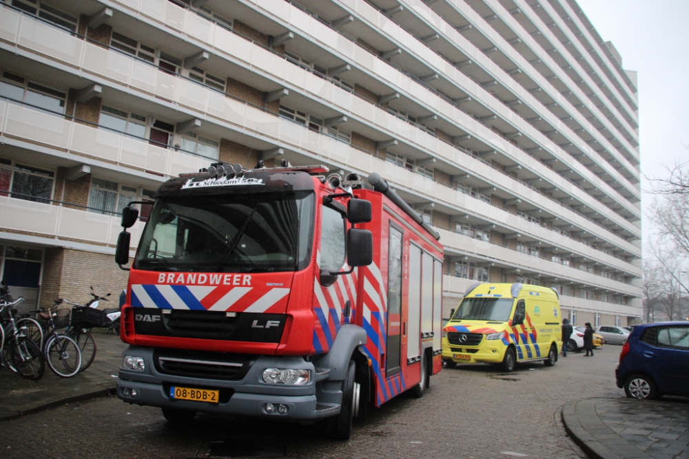 Bewoner nagekeken door ambulancepersoneel na brand in woning