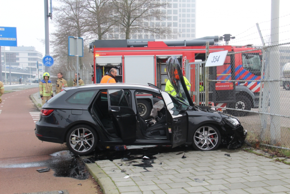 Auto botst tegen betonblokken en hek