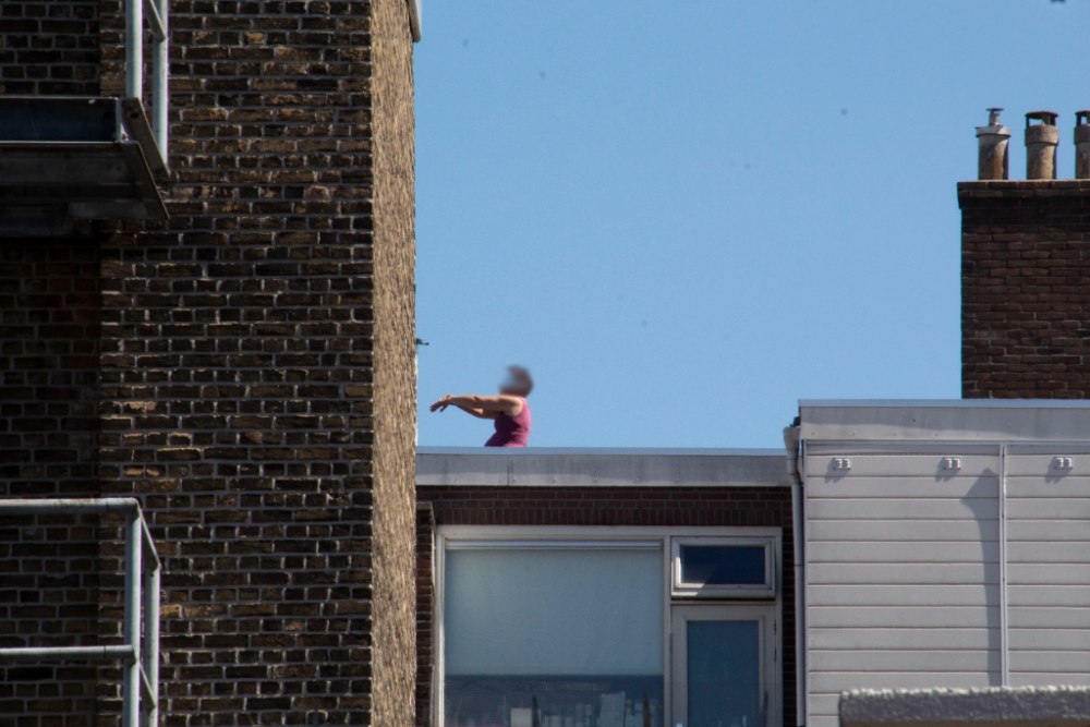 Vrouw staat op dak in centrum, straten afgesloten