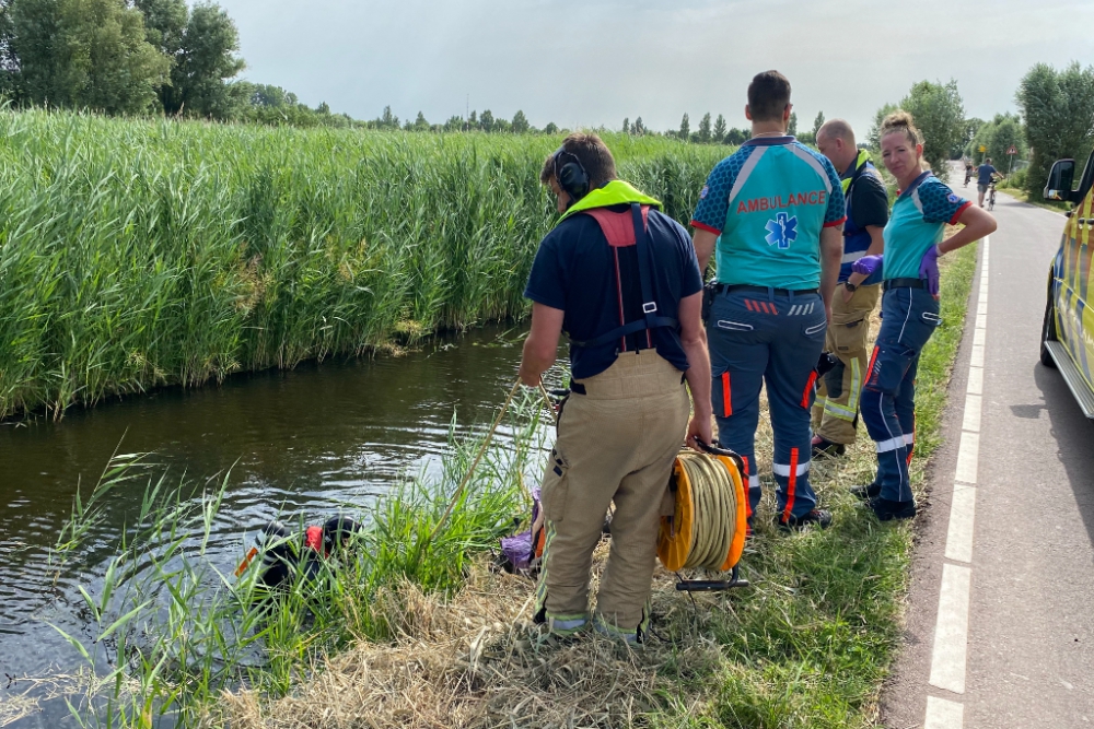 Brandweerduiker doorzoekt sloot na aantreffen wiel op de Woudweg