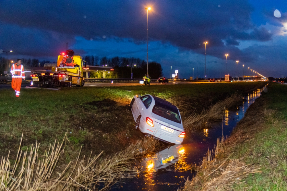 Auto door regenbui van de A20 in de sloot