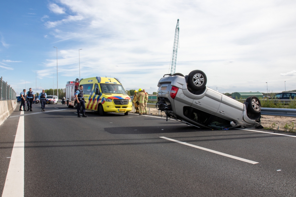 Auto over de kop op de A20; file vanaf Schiedam door afgesloten rijstroken